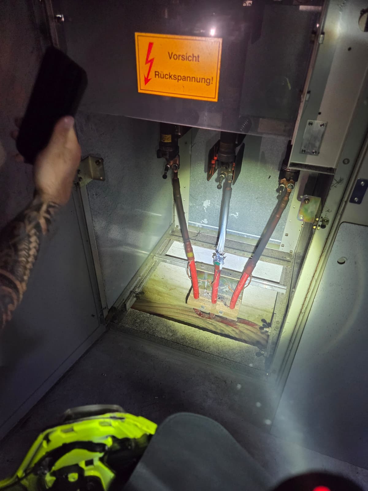 Stromkabel in einem Schaltschrank mit Warnhinweis "Vorsicht Rückspannung!"